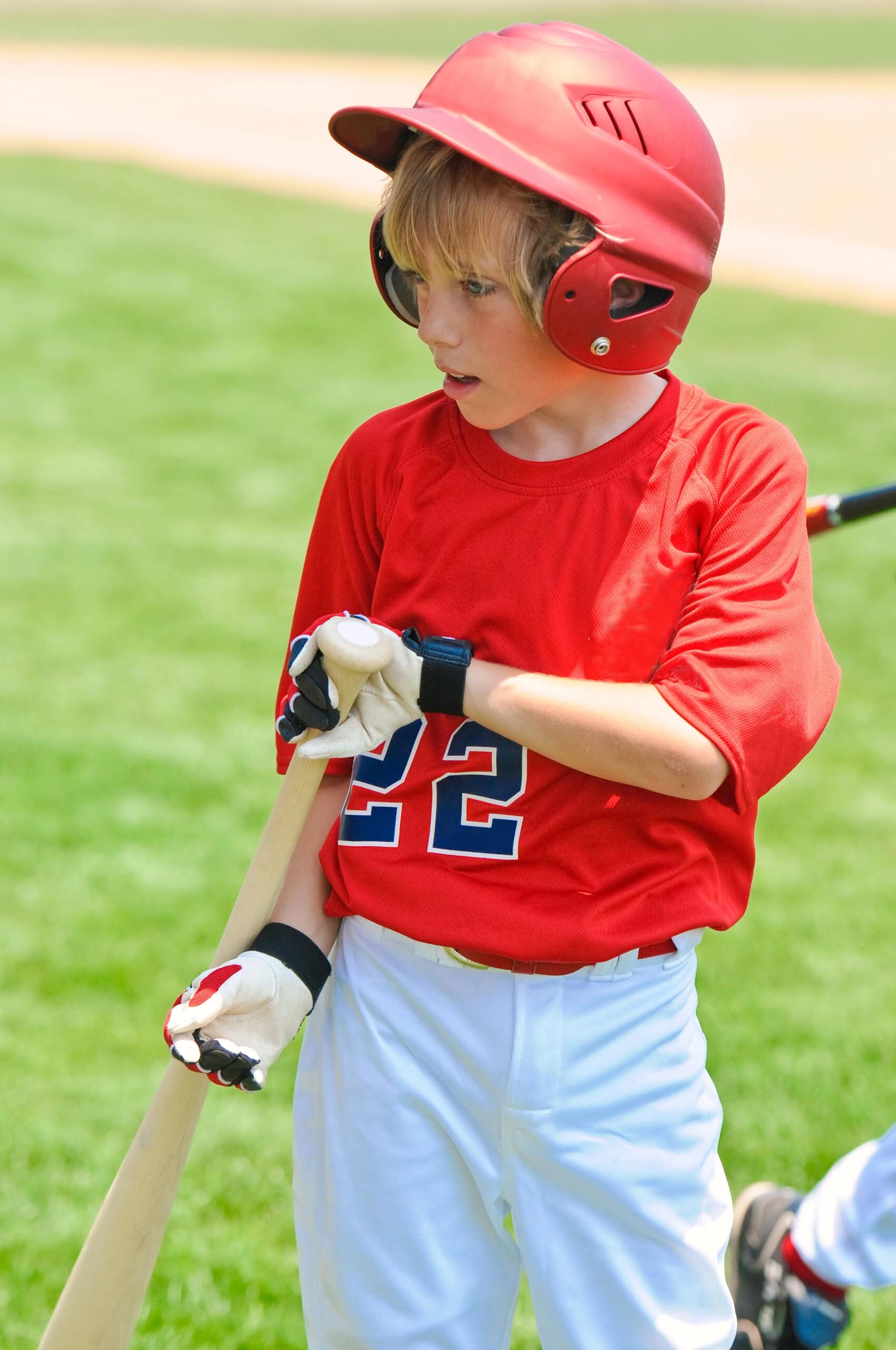 Youth baseball player on deck about to bat.